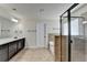 Bright bathroom featuring a double vanity with dark cabinets, a soaking tub, and a glass-enclosed shower at 556 Georgia Cir, Loganville, GA 30052