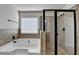 Bathroom featuring a soaking tub, tiled walls and a walk-in shower with glass enclosure and bronze fixtures at 556 Georgia Cir, Loganville, GA 30052