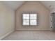 Bright bedroom featuring a large window with blinds and neutral carpet floors at 556 Georgia Cir, Loganville, GA 30052
