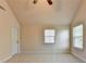 Bedroom featuring large windows with wood blinds, neutral color scheme, and vaulted ceiling at 556 Georgia Cir, Loganville, GA 30052