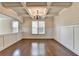 Dining room featuring a coffered ceiling, modern chandelier, and wainscoting at 556 Georgia Cir, Loganville, GA 30052