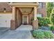 Close-up of the home's entrance with beautiful brick accents and landscaped garden at 556 Georgia Cir, Loganville, GA 30052