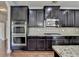 Gourmet kitchen features custom cabinets, granite counters, stainless appliances, and hardwood floors at 556 Georgia Cir, Loganville, GA 30052