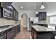 Kitchen features stainless steel appliances, dark cabinets, a granite island, and hardwood floors at 556 Georgia Cir, Loganville, GA 30052