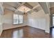 Living room with hardwood floors, wainscoting, a coffered ceiling, and large windows at 556 Georgia Cir, Loganville, GA 30052