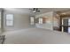 Spacious living room with neutral carpeting, large windows, and a smooth flow into adjacent areas at 556 Georgia Cir, Loganville, GA 30052