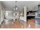 Hardwood floors connect living space to kitchen with dark cabinets, granite counters, and stainless appliances at 556 Georgia Cir, Loganville, GA 30052