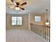 Loft area with plush carpet, neutral walls, a stylish pendant light, and large windows at 556 Georgia Cir, Loganville, GA 30052