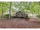 Lush backyard with mature trees, shrubs, and a screened in porch at 9395 Clublands Dr, Alpharetta, GA 30022