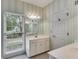 Cozy bathroom with stylish wallpaper, large window with blinds and ample cabinet storage at 9395 Clublands Dr, Alpharetta, GA 30022