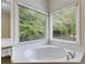 Bathroom showcasing a large soaking tub nestled beneath two large windows for maximum natural light at 9395 Clublands Dr, Alpharetta, GA 30022