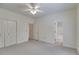 Bright bedroom featuring neutral carpet, ceiling fan and access to an attached bathroom and additional storage at 9395 Clublands Dr, Alpharetta, GA 30022