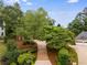 Scenic view of a charming home nestled among mature trees and beautifully landscaped grounds at 9395 Clublands Dr, Alpharetta, GA 30022