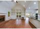 Open-concept living space with fireplace, built-ins, hardwood floors, and kitchen access at 9395 Clublands Dr, Alpharetta, GA 30022