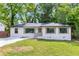 Charming ranch-style home featuring a white painted brick facade, black windows, and a well-manicured lawn at 2026 Rebecca Ln, Decatur, GA 30032