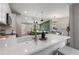 An open kitchen features white countertops, stainless appliances and stylish lighting and connects seamlessly with the dining area at 2026 Rebecca Ln, Decatur, GA 30032