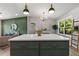 Modern kitchen features a large island with a white countertop, shaker cabinets, and brass hardware, plus pendant lighting at 2026 Rebecca Ln, Decatur, GA 30032