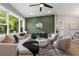 Stylish living room with decorative green accent wall, plush seating, and large windows offering natural light at 2026 Rebecca Ln, Decatur, GA 30032