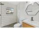 Bathroom featuring modern fixtures, patterned accent wall, and hexagon mirror at 2211 Macon Sw Dr, Atlanta, GA 30315