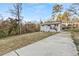 Exterior of single-story home with long driveway and front yard with mature trees at 2211 Macon Sw Dr, Atlanta, GA 30315