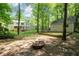 The backyard features a fire pit, lush trees, a well maintained lawn, and the home in the background at 3078 Alberta Dr, Marietta, GA 30062