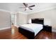 Cozy bedroom featuring hardwood floors, ceiling fan, and a door to the bathroom at 3078 Alberta Dr, Marietta, GA 30062