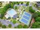 Aerial view of a pool, tennis courts, playground, parking, and manicured lawns in a community at 4140 Lansfaire Ter, Suwanee, GA 30024
