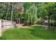 Fenced backyard with established landscaping, mature trees, and healthy green grass at 4140 Lansfaire Ter, Suwanee, GA 30024