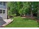 An expansive lawn features lush green grass, mature trees, and professional landscaping at 4140 Lansfaire Ter, Suwanee, GA 30024