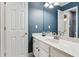 Stylish bathroom showcases a white vanity and white fixtures against bold blue walls at 4140 Lansfaire Ter, Suwanee, GA 30024