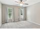 Spacious bedroom with neutral walls, carpet, ceiling fan and two windows with natural light at 4140 Lansfaire Ter, Suwanee, GA 30024