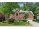Charming two-story brick home featuring lush landscaping, a well-manicured lawn, and an attached two-car garage at 4140 Lansfaire Ter, Suwanee, GA 30024