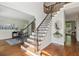 Elegant foyer showcasing a staircase with decorative metal spindles, hardwood floors, and access to adjacent rooms at 4140 Lansfaire Ter, Suwanee, GA 30024