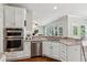Bright kitchen featuring white cabinets, stainless steel appliances, granite countertops, and an open layout at 4140 Lansfaire Ter, Suwanee, GA 30024
