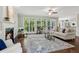 Cozy living room with a fireplace, large windows, comfortable seating, and an attractive area rug at 4140 Lansfaire Ter, Suwanee, GA 30024