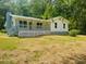 Ranch-style home with a covered front porch and mature trees at 97 East Rd, Covington, GA 30016