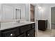 Bathroom with dark vanity, white countertop, and view into hallway and additional bathroom at 2113 Dodson Woods Dr, Fairburn, GA 30213