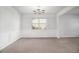 Bright dining room with modern chandelier, large window, and classic wainscoting at 2113 Dodson Woods Dr, Fairburn, GA 30213