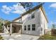 The back exterior view of a two-story home featuring a large patio with ceiling fans and fenced backyard at 2113 Dodson Woods Dr, Fairburn, GA 30213