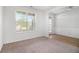 Bright living room with large window and neutral carpet, leading to hardwood floor entryway at 2113 Dodson Woods Dr, Fairburn, GA 30213