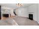 Open-concept living space with hardwood floors leading to a cozy carpeted living room with a fireplace at 2113 Dodson Woods Dr, Fairburn, GA 30213
