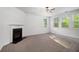 Bright living room featuring a fireplace, neutral carpet, and large windows at 2113 Dodson Woods Dr, Fairburn, GA 30213
