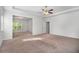 Bright main bedroom with tray ceiling, ceiling fan, carpet, and ample natural light at 2113 Dodson Woods Dr, Fairburn, GA 30213