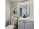 Modern half bath with black hardware, updated mirror and vanity, and a neutral color palette at 8007 Northcrest Dr, Jonesboro, GA 30238