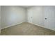 Neutral bedroom with carpet flooring and white trim, with doors on the right side of the space at 8007 Northcrest Dr, Jonesboro, GA 30238