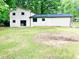 The rear exterior view of a home with a lush green lawn and lots of trees at 8007 Northcrest Dr, Jonesboro, GA 30238