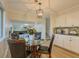 Bright eat-in kitchen with hardwood floors, stainless appliances, and a modern hanging light fixture at 8007 Northcrest Dr, Jonesboro, GA 30238