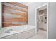 Luxurious bathroom showcasing a soaking tub, stylish accent wall, and white tile flooring at 1064 Highway 20 E, Mcdonough, GA 30252