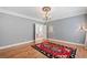 Bedroom with grey walls, wood flooring, and decorative rug with a view into bathroom at 1064 Highway 20 E, Mcdonough, GA 30252