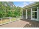Deck with white railing provides a view of screened in porch and wooded back yard at 1064 Highway 20 E, Mcdonough, GA 30252